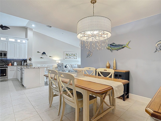 dining room with vaulted ceiling, a chandelier, and light tile patterned flooring