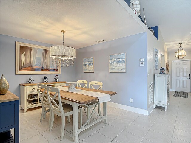 tiled dining space featuring a chandelier