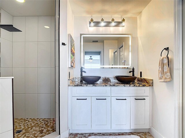 bathroom featuring vanity and tiled shower