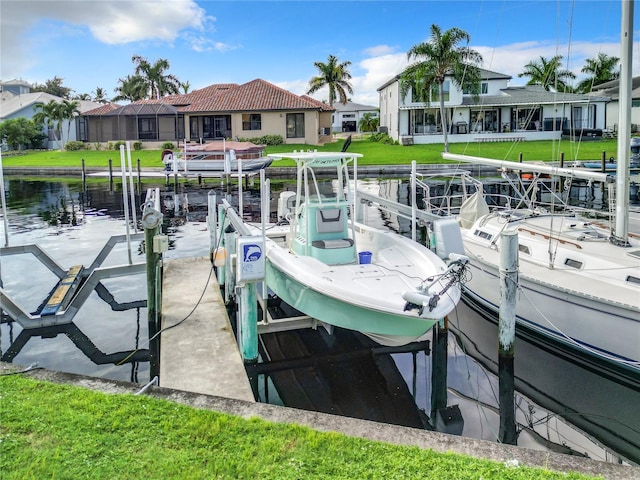 view of dock with a lawn, a water view, and glass enclosure