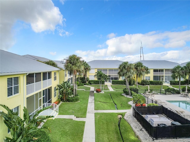 view of property's community with a swimming pool and a yard