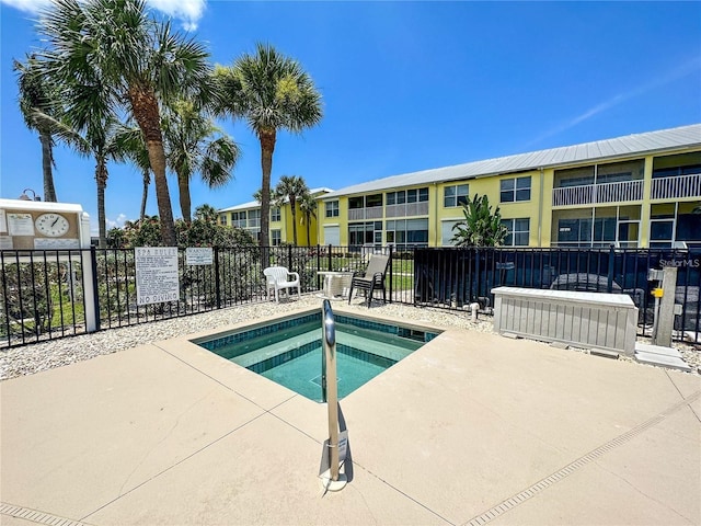 view of swimming pool featuring a community hot tub and a patio