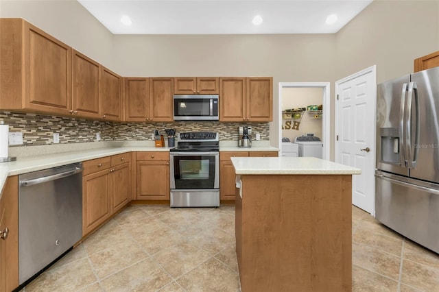 kitchen featuring separate washer and dryer, decorative backsplash, a center island, and stainless steel appliances