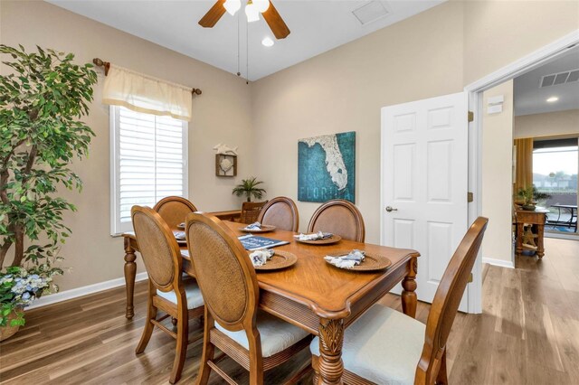 dining area with dark hardwood / wood-style floors and ceiling fan