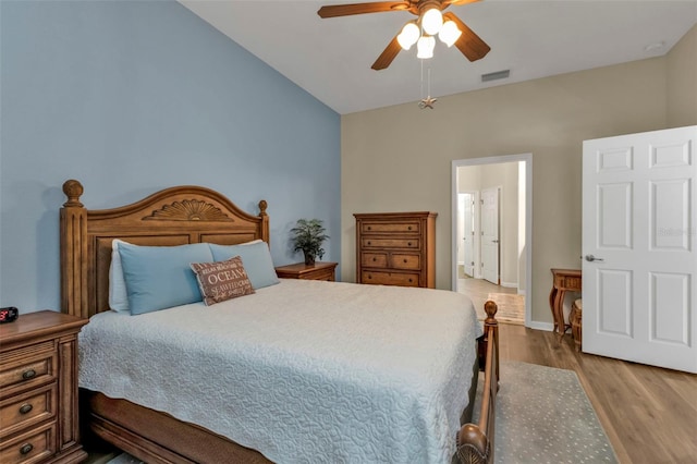 bedroom featuring ceiling fan, light hardwood / wood-style flooring, and vaulted ceiling