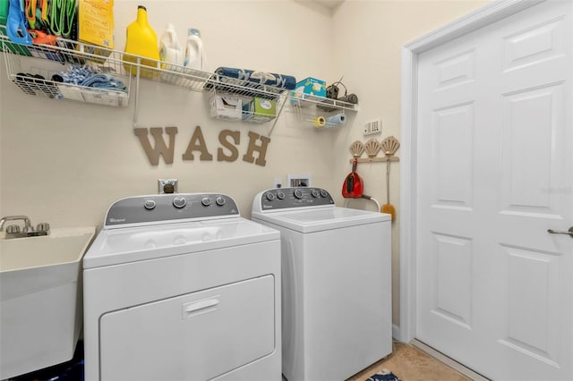 laundry area with washer and clothes dryer, sink, and tile patterned flooring