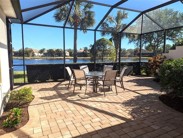 view of patio / terrace with glass enclosure and a water view