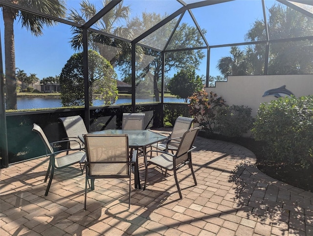 view of patio / terrace with a lanai, a water view, and pool water feature