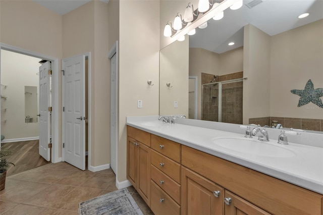 bathroom featuring tile patterned floors, vanity, and a shower with shower door