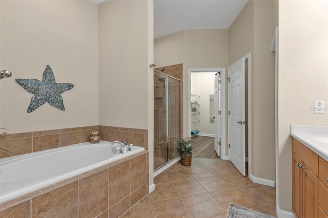 bathroom with vanity, tile patterned flooring, and plus walk in shower