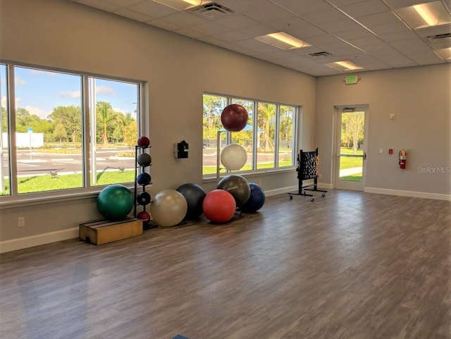 exercise area with a drop ceiling and wood-type flooring