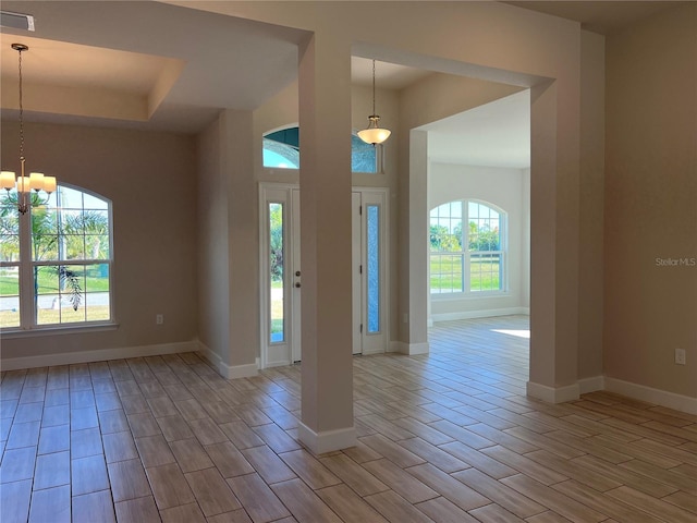 entryway featuring plenty of natural light, an inviting chandelier, and light wood-type flooring