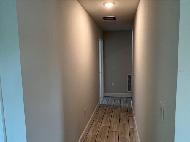 hallway with hardwood / wood-style flooring