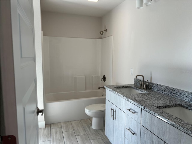 full bathroom with hardwood / wood-style floors, vanity, toilet, and  shower combination