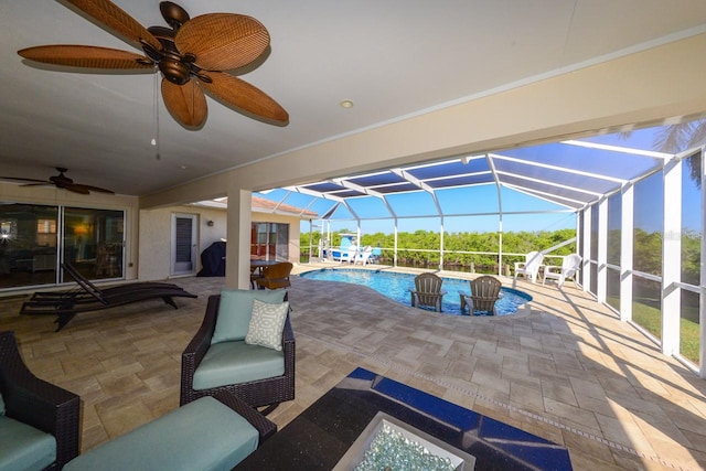 view of pool featuring a patio, glass enclosure, and ceiling fan