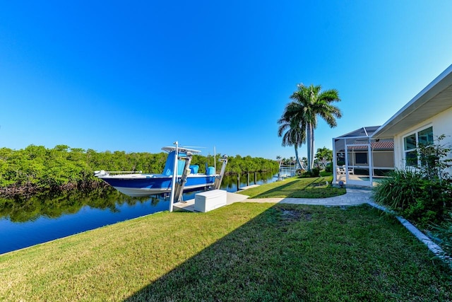 view of yard with glass enclosure, a boat dock, and a water view