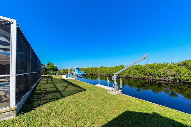 view of yard with a dock, glass enclosure, and a water view