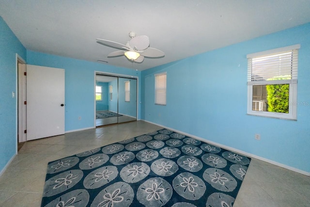 empty room featuring tile patterned flooring, ceiling fan, and plenty of natural light