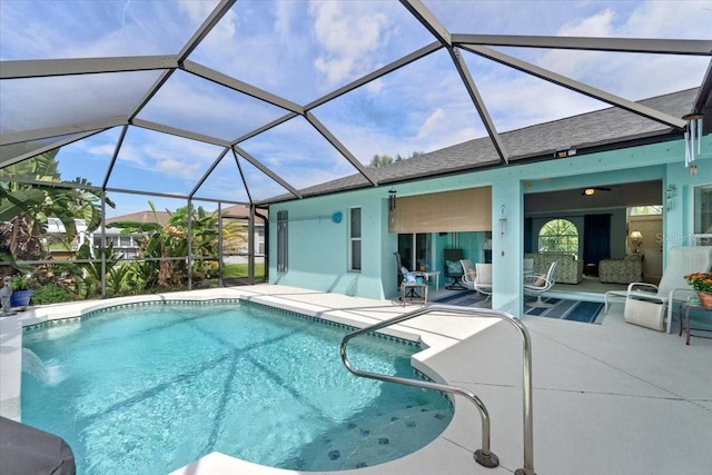 view of pool with a lanai, a patio area, and pool water feature