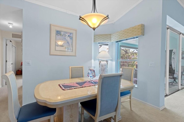 dining room with crown molding and light carpet