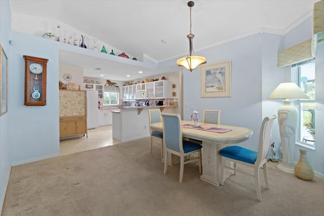 dining area with vaulted ceiling, light colored carpet, and ornamental molding