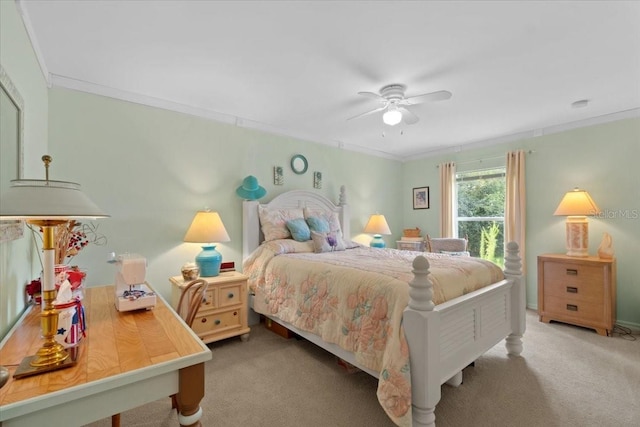 carpeted bedroom featuring ceiling fan and crown molding