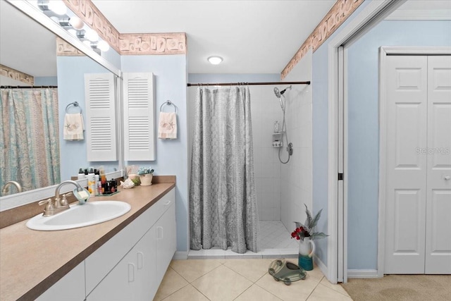 bathroom with tile patterned flooring, vanity, and walk in shower