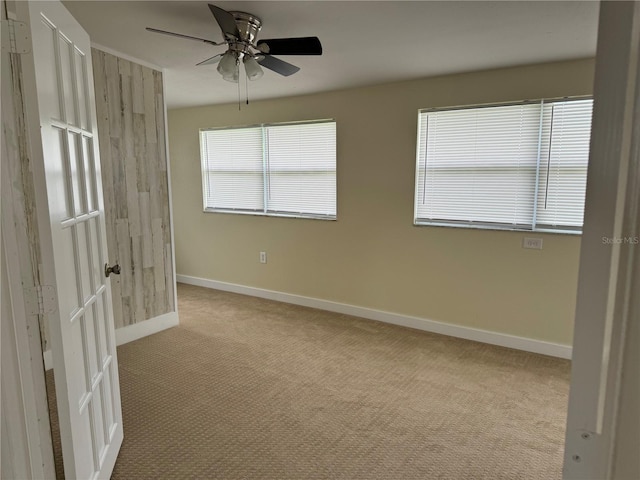 carpeted spare room featuring ceiling fan