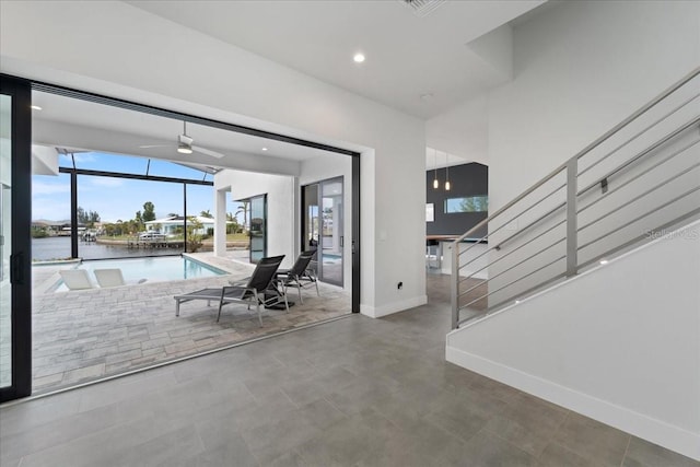 unfurnished dining area with a water view and ceiling fan