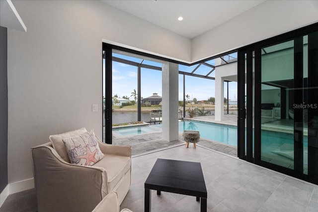 sitting room with a water view and a swimming pool