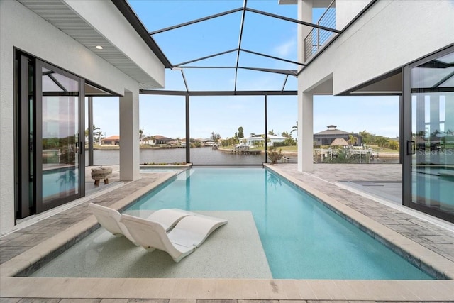 view of pool featuring a patio, a water view, and glass enclosure