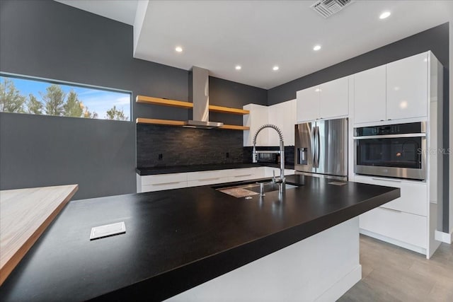 kitchen with sink, white cabinetry, stainless steel appliances, tasteful backsplash, and island exhaust hood