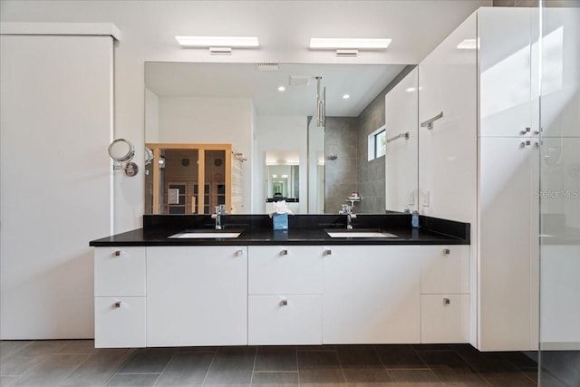 bathroom with vanity and a tile shower