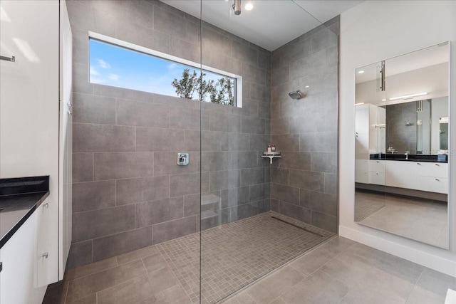 bathroom featuring tiled shower, vanity, and tile patterned floors