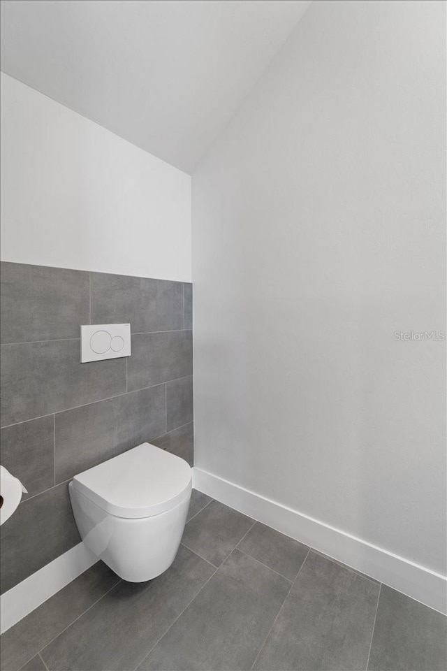 bathroom featuring vaulted ceiling, tile patterned floors, and toilet