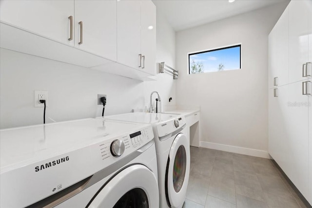 laundry area featuring cabinets, light tile patterned floors, and washing machine and clothes dryer