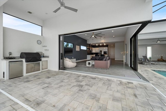 view of patio with a grill, ceiling fan, and exterior kitchen