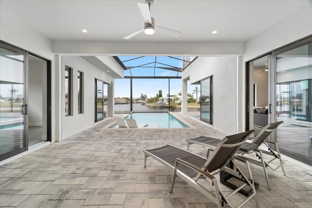 view of swimming pool featuring ceiling fan and a water view