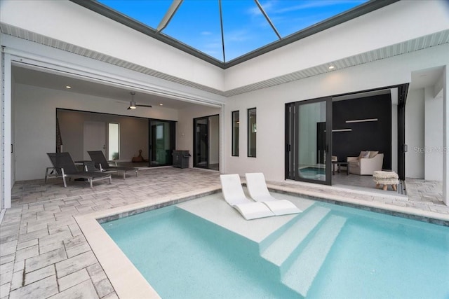 view of swimming pool featuring a patio, ceiling fan, and glass enclosure