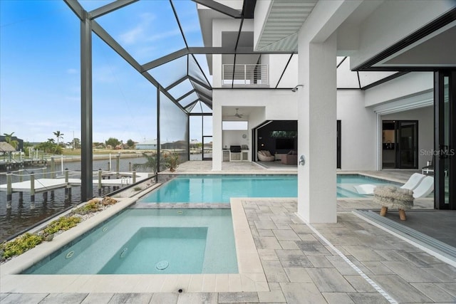 view of pool featuring a water view, glass enclosure, and a patio area