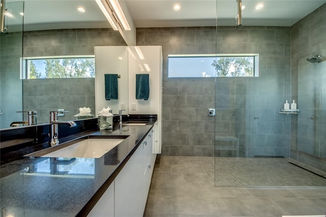 bathroom featuring plenty of natural light, double vanity, a sink, and walk in shower