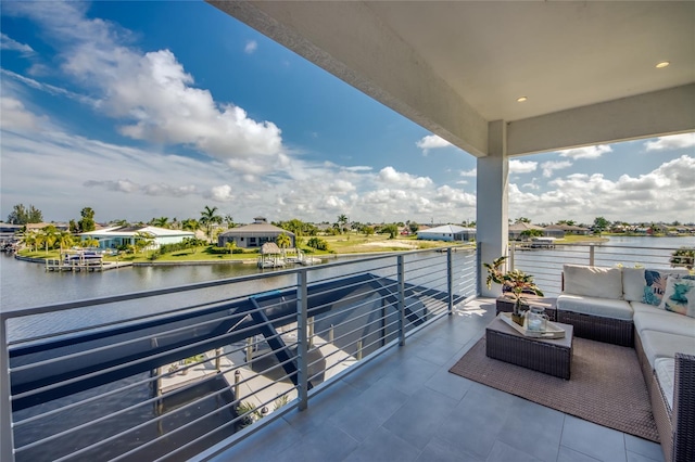 balcony featuring a water view and an outdoor living space