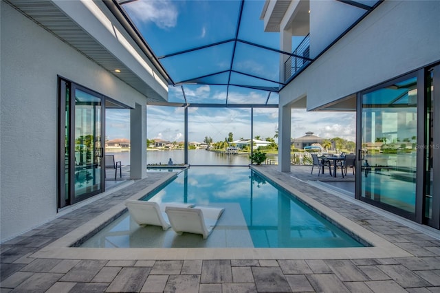 outdoor pool with a patio, a water view, and a lanai