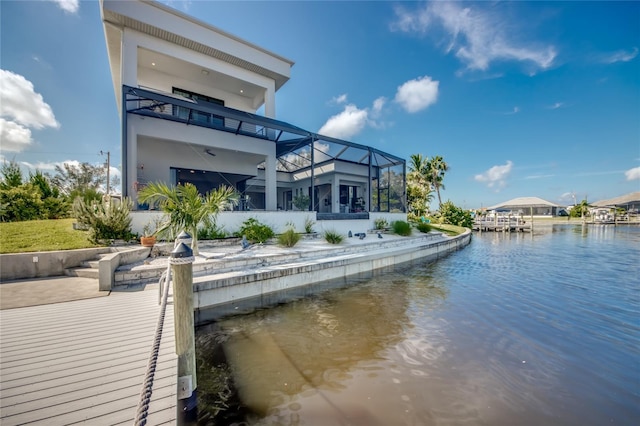 back of house featuring a lanai, a water view, and a balcony