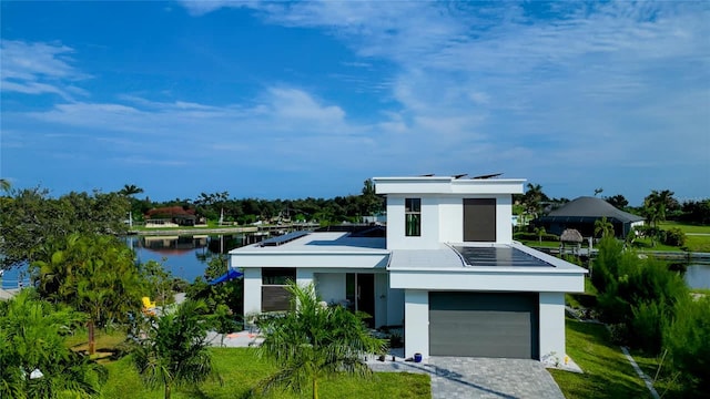 3715 NW 9th Ter, Cape Coral, FL 33993 - modern home featuring stucco siding, a water view, decorative driveway, and an attached garage