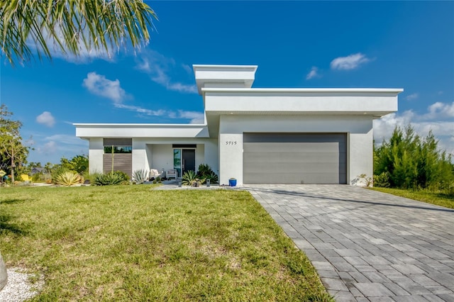 3715 NW 9th Ter, Cape Coral, FL 33993 - view of front facade with stucco siding, a garage, a front yard, and decorative driveway