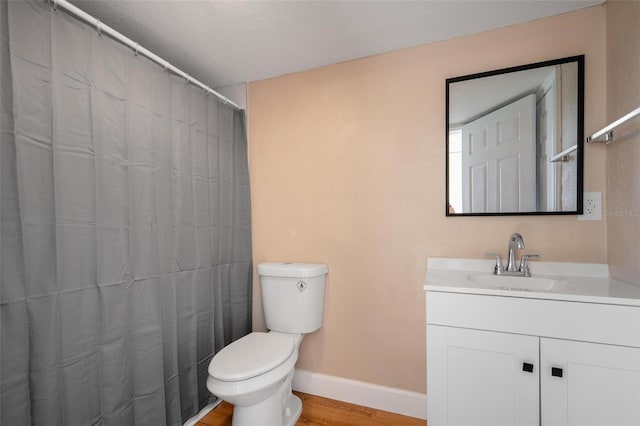 bathroom with hardwood / wood-style flooring, vanity, and toilet