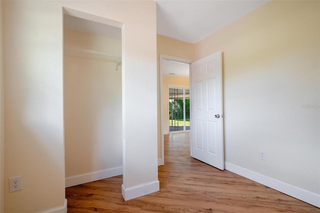 unfurnished bedroom with a closet and light wood-type flooring