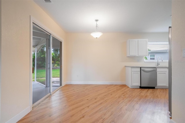 kitchen featuring white cabinets, dishwasher, plenty of natural light, and hanging light fixtures