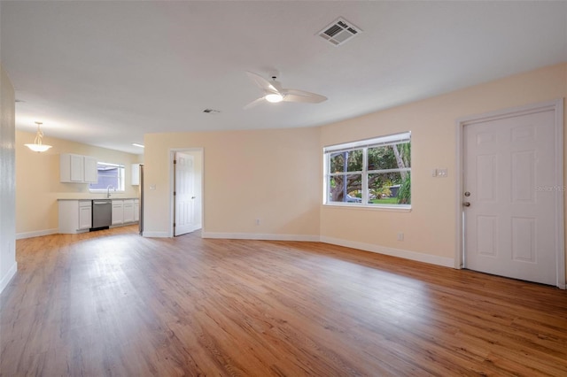 unfurnished living room featuring ceiling fan, light hardwood / wood-style flooring, and sink